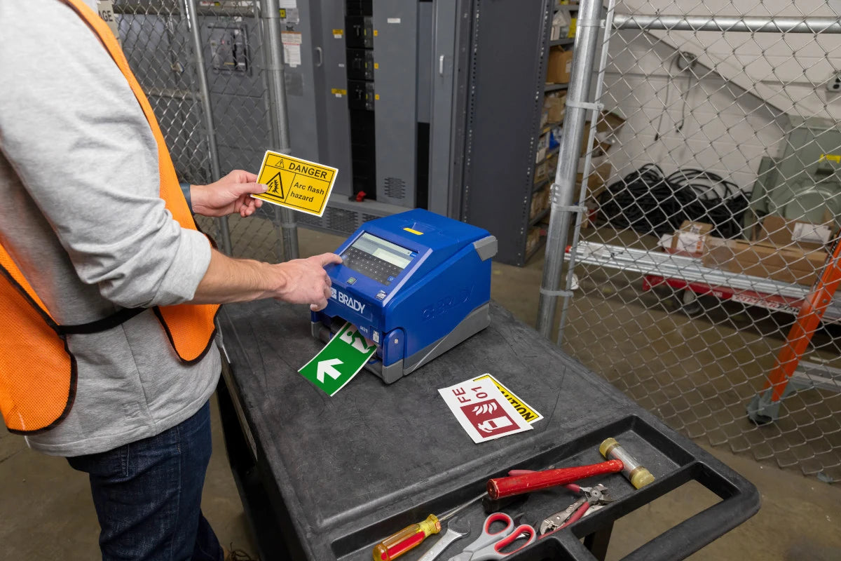 Printing a yellow warning label with the i4311 beside other safety signs